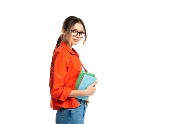 joven estudiante en gafas sosteniendo libros aislados en blanco  - Foto, Imagen