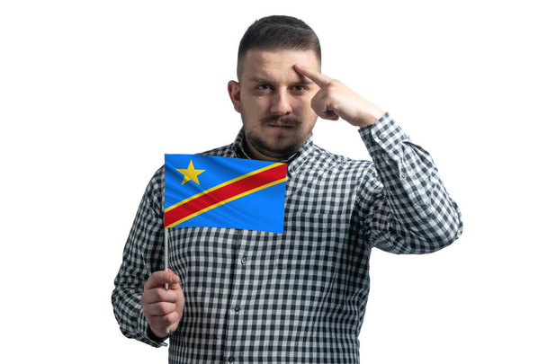 コンゴ民主共和国の旗を持っている白人と指が白い背景に隔離された頭の上に寺院に触れる. - 写真・画像