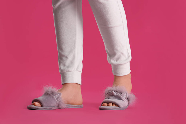Woman in fluffy slippers on pink background, closeup - Foto, immagini