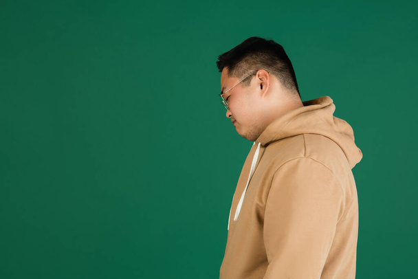 Asian mans portrait isolated over green studio background with copyspace - Fotó, kép
