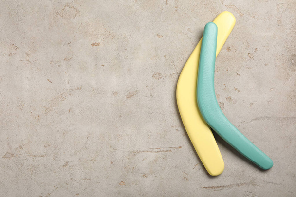 Boomerangs on light grey stone background, flat lay. Space for text - Foto, imagen