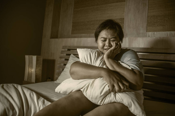 dramático retrato de joven triste y deprimida gorda y gordita chica asiática llorando impotente en la cama en casa víctima de bullying y discriminación causa de más tamaño y sobrepeso - Foto, imagen
