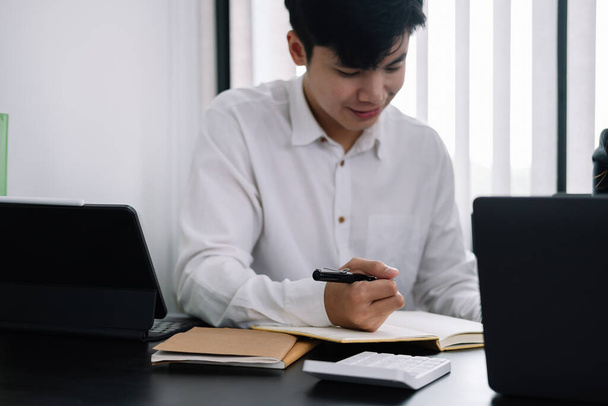 Podnikatel drží pero a bere na vědomí při schůzce v kanceláři - Fotografie, Obrázek