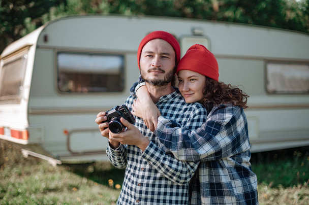 Casal romântico com uma câmera na natureza perto do trailer em casa. - Foto, Imagem