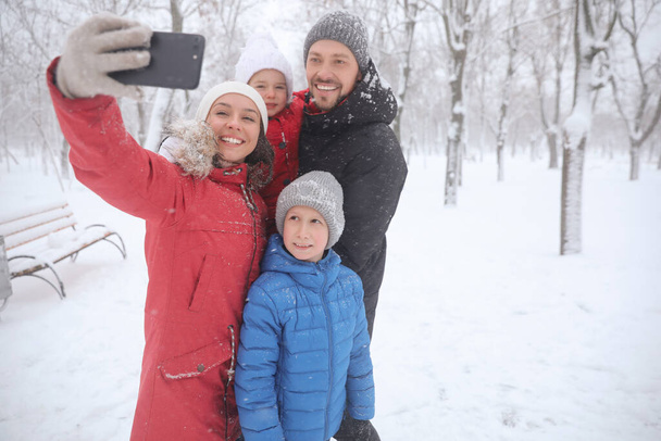Happy family taking selfie outdoors on winter day. Christmas vacation - Photo, Image