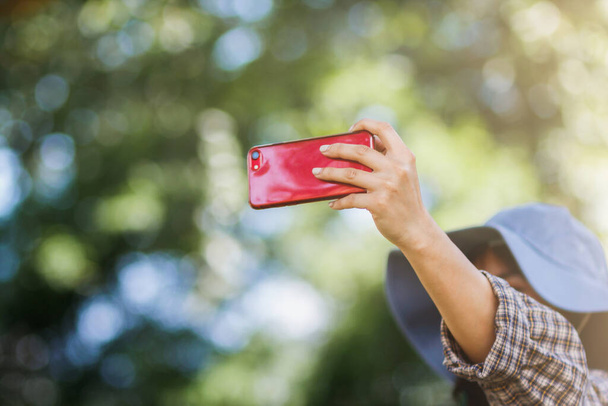 Une jeune touriste utilise un selfie pour prendre un selfie avec une belle vue à partager sur les médias sociaux. L'idée de prendre un selfie si vous êtes dans une destination touristique à partager sur les médias sociaux. - Photo, image