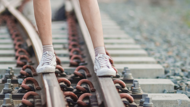 Homályos kép, egy fiatal nő egyedül sétál le a vasúton, és a tervezett úticél felé. Fiatal turisták boldogan sétálnak a vasúton egyedül esténként - Fotó, kép