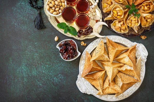 Arabic Cuisine. Ramadan Kareem Festive. Ramadan menu, of Egyptian oriental dessert: assorted arabian pancake katayef and dates, pistachio. Top view. Copy space. - Photo, Image
