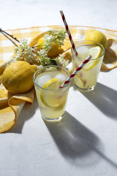 Refreshing homemade glass lemonade with ice and mint in sunlight on white background - Foto, Imagem
