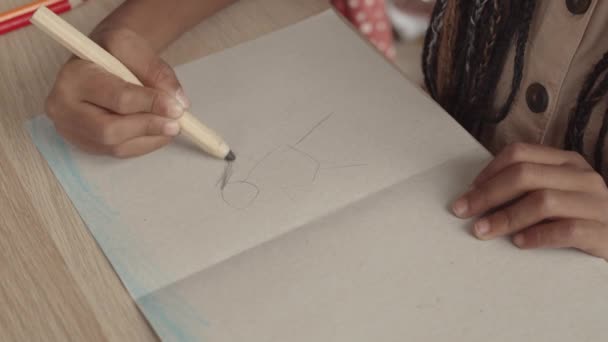 Alto angolo di ritagliato bambino irriconoscibile persona disegno con matita su carta - Filmati, video