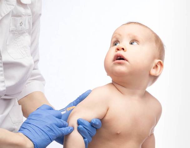 Kinderarzt oder Krankenschwester bereit, einem Baby während der Coronavirus-Covid-19-Pandemie eine intramuskuläre Injektion eines Impfstoffes zu verabreichen - Foto, Bild