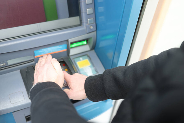 Muž zadává pin kód v bankomatu a přikrývá ho rukou detailně - Fotografie, Obrázek