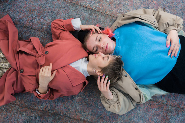 яскраві дівчата нетрадиційної сексуальної орієнтації лежать на тротуарі
 - Фото, зображення
