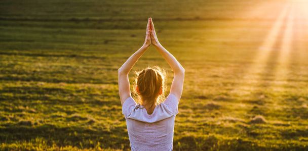 mulher em uma postura de equilíbrio ao pôr do sol ioga ao ar livre - Foto, Imagem