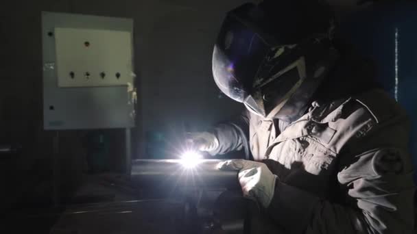 Работник производства сваривает металлоконструкции аргональной сваркой - Кадры, видео