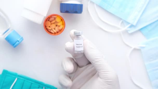 latexové rukavice držící skleněnou ampulovou vakcínu, s kopírovacím prostorem  - Záběry, video