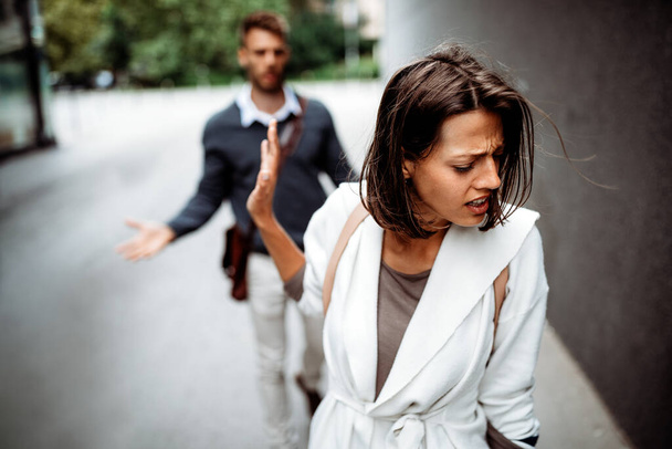Sad young woman and man outdoor on street having relationship problems, conflicts - Foto, imagen