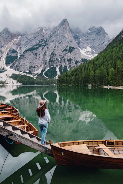 Woman traveler in a hat standing at the bank of beautiful lake - Foto, Imagen