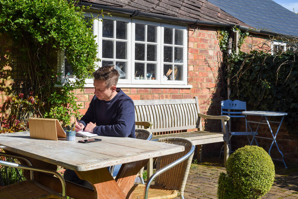 Férfi dolgozik otthonról távirányító online dolgozik a kertben - Fotó, kép