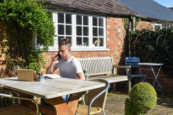 Férfi dolgozik otthonról távirányító online dolgozik a kertben - Fotó, kép