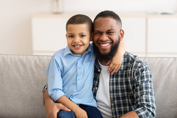 felice afroamericano papà e figlio abbraccio in posa a casa - Foto, immagini