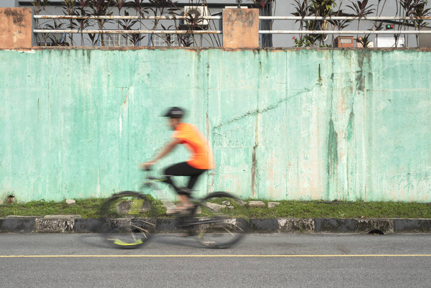Bulanık hareketlerle bisiklete binen bir adam. Ulaşım ve sağlıklı yaşam tarzı kavramı. - Fotoğraf, Görsel
