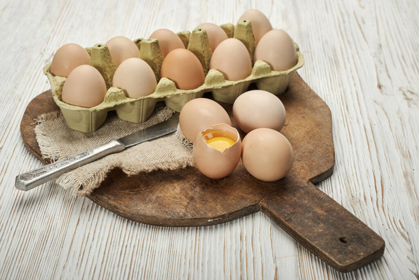 Γκρο πλαν άποψη των ακατέργαστων αυγών κοτόπουλου σε κουτί αυγών σε ξύλινο φόντο. Ωμά αυγά κοτόπουλου σε κουτί αυγών βιολογική τροφή για καλή υγεία υψηλής πρωτεΐνης . - Φωτογραφία, εικόνα