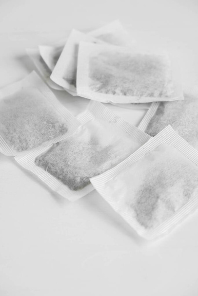 Grupo de bolsas de té secas cuadradas sobre un fondo blanco. Copiar, espacio vacío para texto. - Foto, imagen