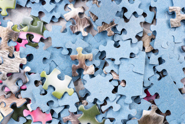 Many pieces of an unfinished puzzle. Pile of jigsaw puzzle pieces - Foto, Imagem