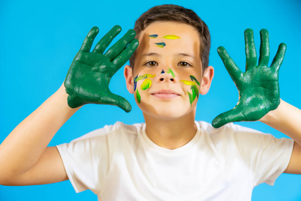 Cute boy with finger paint isolated over blue background. - Fotografie, Obrázek