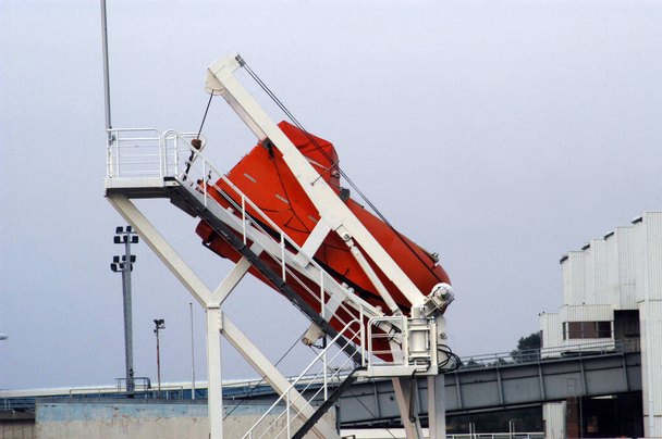 ein rotes Rettungsboot oder Rettungsboot als Sicherheitsvorrichtung in der Seefahrt - Foto, Bild