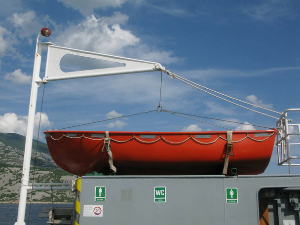 ein rotes Rettungsboot oder Rettungsboot als Sicherheitsvorrichtung in der Seefahrt - Foto, Bild