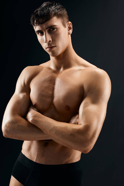 σέξι άντρας με φουσκωμένο κορμό αθλητή σκοτεινό φόντο στούντιο - Φωτογραφία, εικόνα