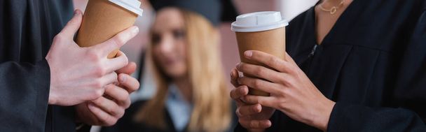 Vue recadrée des diplômés interracial tenant du café à emporter, bannière  - Photo, image