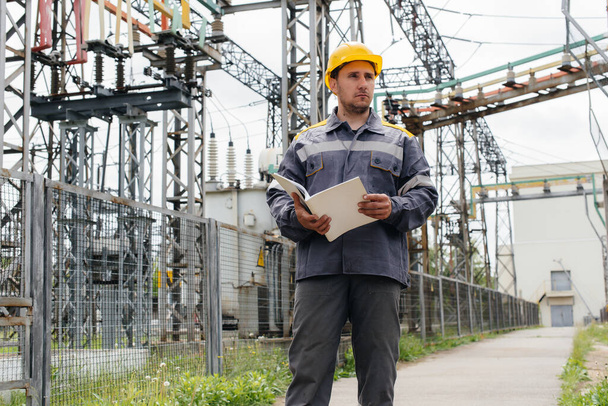 The energy engineer inspects the equipment of the substation. Power engineering. Industry - Fotó, kép