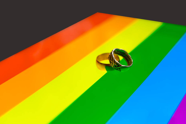 Eheringe auf Regenbogenfahne. Homo-Ehe-Konzept. Ringe auf einer Regenbogenfahne - Foto, Bild