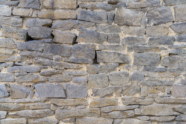 La pared está hecha de piedra. Primer plano. La antigua mampostería de piedra de la valla del monasterio. Textura de muro de piedra (Ural, Rusia) - Foto, Imagen