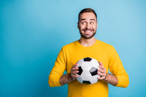 Photo portrait of man with ball smiling looking blank space curious isolated on bright blue color background - Foto, Imagen