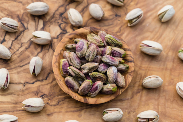 Salted pistachios on olive wood - Foto, immagini