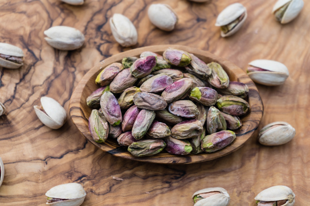 Salted pistachios on olive wood - Photo, Image