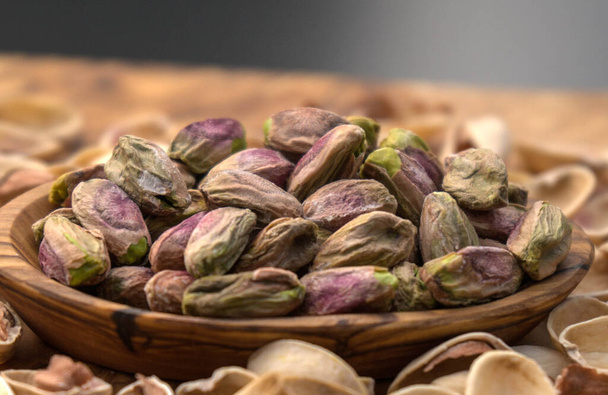 Salted pistachios on olive wood - Photo, Image