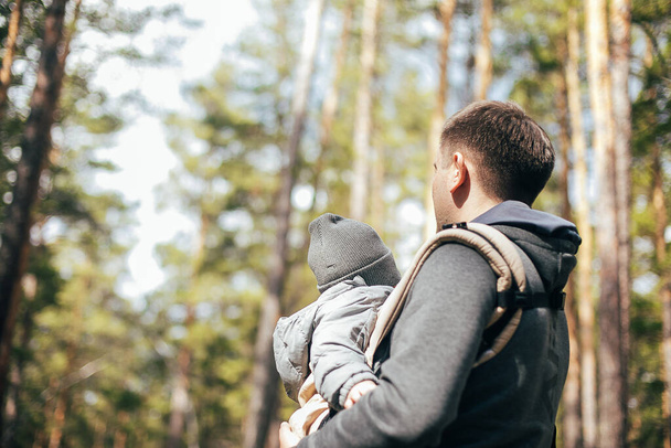 Father carrying his baby boy in ergo bag. Lifestyle, authentic moment. Concept of leisure outdoor, staycation, mental health - Фото, зображення