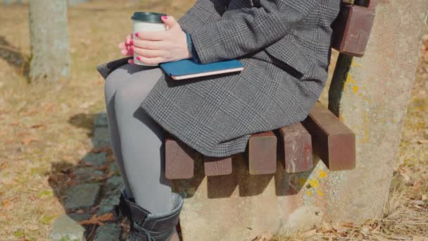 Femme avec emporter tasse de café et comprimé sur banc - Séquence, vidéo