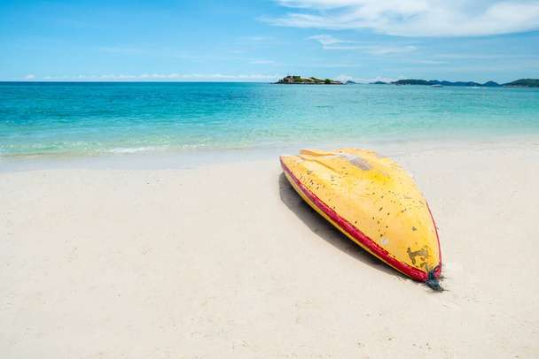 Kayak amarillo en la playa tropical en el hermoso día claro. Hermosa playa de arena clara y mar tropical azul claro. Océano azul suave ola en la playa de arena. Agua salada, agua clara. Junto al mar. Copiar espacio. - Foto, imagen