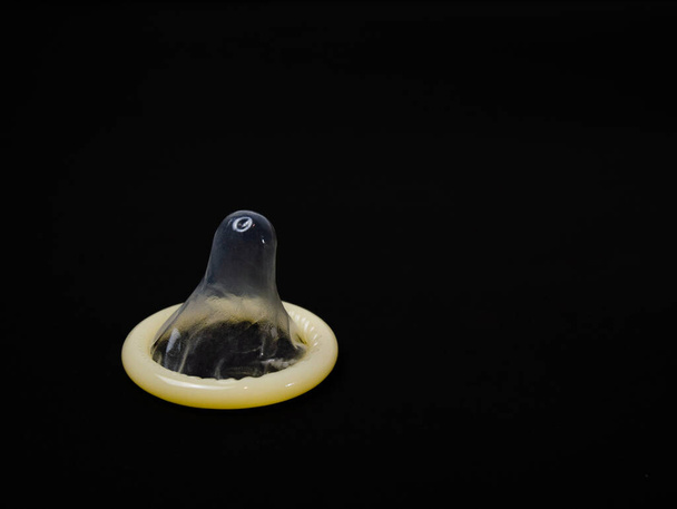 Condom σε πακέτο σε μαύρο φόντο.jpg - Φωτογραφία, εικόνα