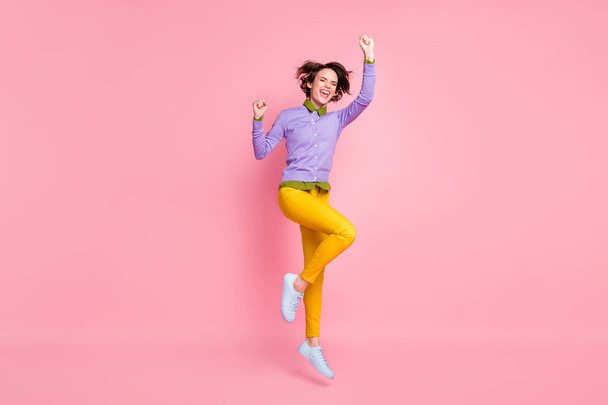 Full size profile photo of lady jump up raise fists lucky win wear jumper yellow pants sneakers isolated pink color background - Photo, Image