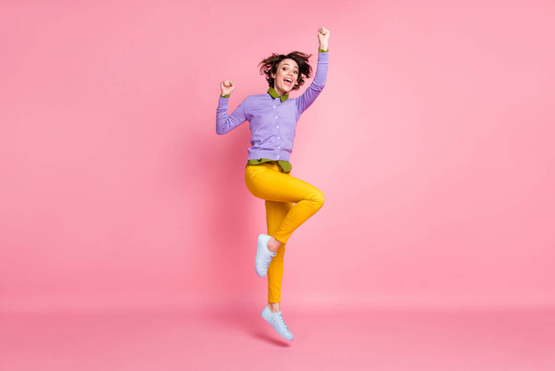 Full length photo of funny student lady jump up wear purple jumper yellow pants sneakers isolated pink color background - Фото, зображення