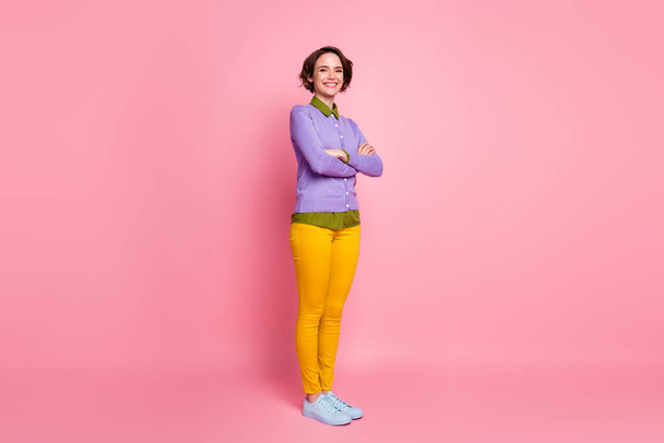 Full size photo of funny lady good mood arms crossed wear jumper pants sneakers isolated pink color background - Фото, зображення