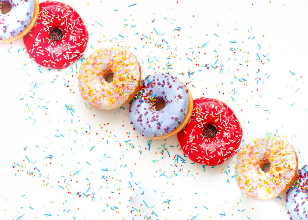 Кольорові пончики з барвистими пружинами на білому тлі. National Donut or Doughnut day Копіювальний простір - Фото, зображення
