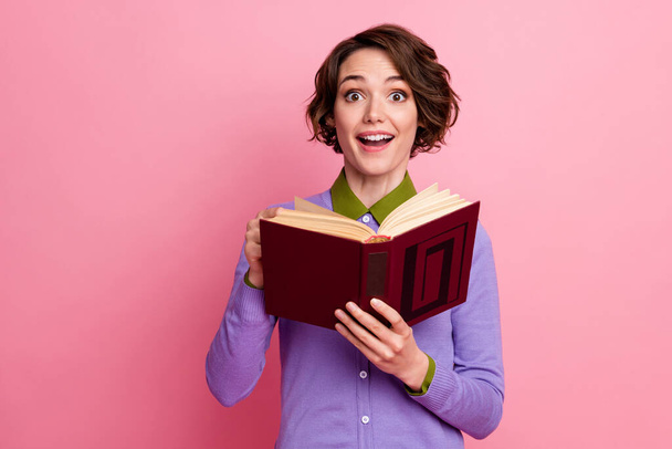 Photo of charming funny lady hold book read story interesting plot wear purple jumper isolated pink color background - Foto, immagini